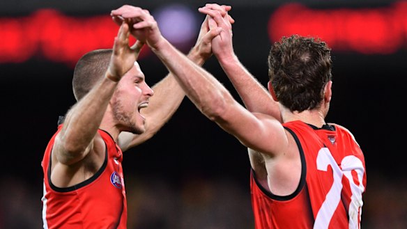 Bombers David Zaharakis and Mitch Brown celebrate a goal on their way to victory at Adelaide Oval.