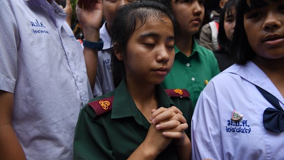 Friends and classmates of the trapped boys in Tham Luang cave gather at the staging area to pray.