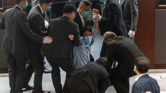 Pro-democracy member of the Hong Kong Legislative Council Ted Hui Chi-fung being removed by security during a scuffle with pro-Beijing legislators.