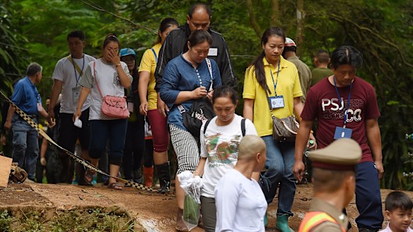 The families of the trapped boys and their coach return from praying at Tham Luang cave on Saturday.