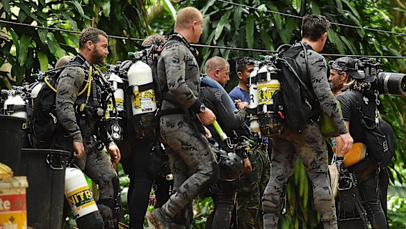 Members of the Australian dive team walk down the track that leads to the cave entrance where the rescue operations are being planned for the 12 boys and their soccer coach who have been trapped inside Tham Luang cave.