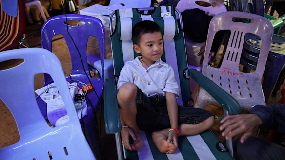 Beam Wongsookjan, 5, watching footage of his brother of Akekarat Wongsookjan 14, who is trapped in the cave.