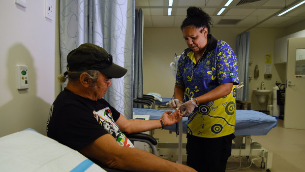 Health worker Vicky Connolly checks the sugar levels of patient Rick McEwan at the Tharawal Aboriginal Corporation Aboriginal Medical Service in Airds.