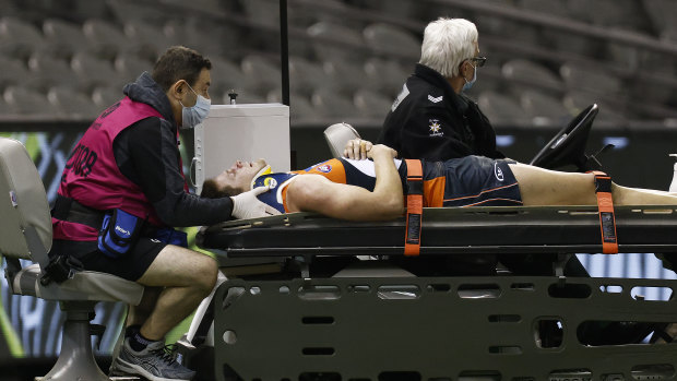 Jacob Hopper of the Giants is stretchered off the ground.