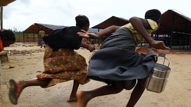 Avoiding guards and a long queue, Rohingya children run towards a Turkish aid agency food distribution site in Shofiullah Kata Camp in the Moynargona area of Cox’s Bazar . The refugee camps in Cox’s Bazar are home to over 900,000 Rohingya refugees who fled Myanmar in August 2017. 