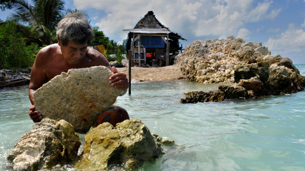 A homeowner in Kiribati rebuilds a sea wall to protect his house on the island of Tarawa.