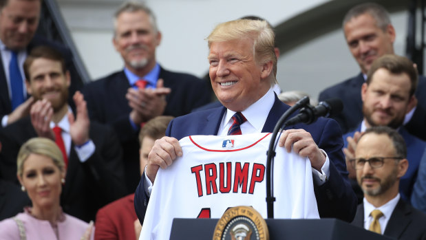Absentees: President Donald Trump holds up a jersey presented to him by the Major League champion Red Sox.