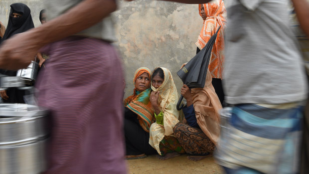Rohingya refugee women wait in their line for a meal provided by a Turkish aid agency at a food distribution site in Shofiullah Kata Camp in Bangladesh.