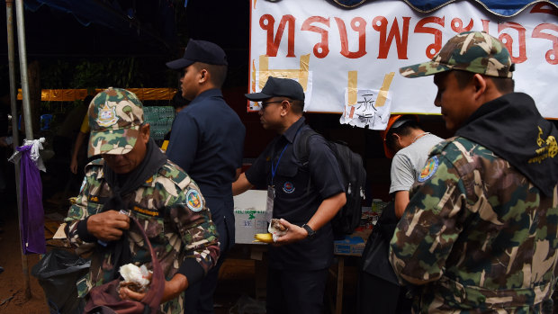 Thai rescuers collect food at the base camp at Tham Luang Cave.