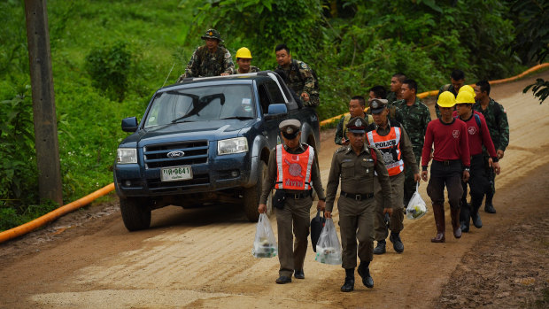 Thai police and military walk towards the cave on Wednesday morning.