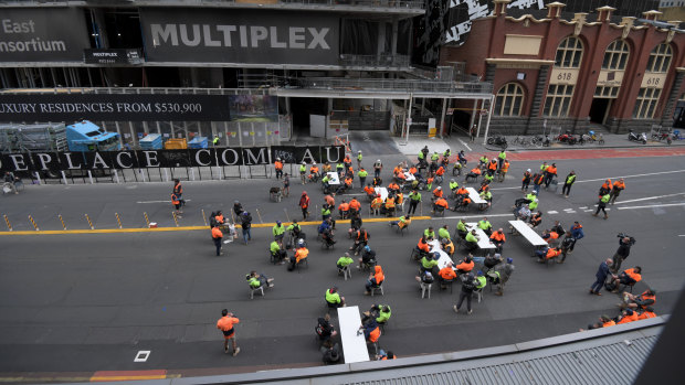 Construction workers using a street in Melbourne’s CBD as a tearoom on Friday. 