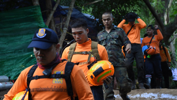 Thai military and volunteers return from Tham Luang cave to the base camp on Thursday.