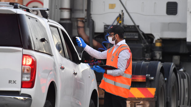 A Cedar Meats employee returns to work and is temperature-tested on the way into the facility. 