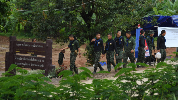 Thai rescue volunteers return from the base camp near Tham Luang cave on day two of the rescue operation.