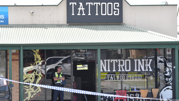 A police officer guards the Nitro Ink tattoo parlor after February's shooting.