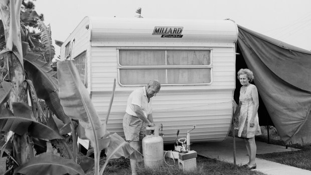 A retired couple change the gas bottle on an Australian-made Millard Capri caravan. 