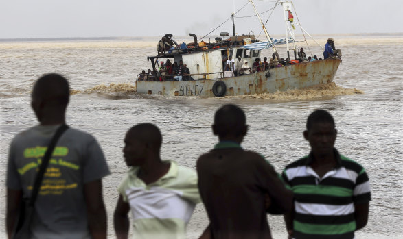 A boat brings displaced families ashore after they were rescued from a flooded area of Buzi district, 200 kilometres from Beira in Mozambique on Saturday.