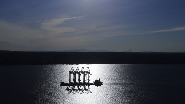 A heavy-lift ship carrying four  container cranes is silhouetted by the sun near Tacoma, Washington. Most economists were already worried that the odds of a recession are rising, and most of the worries stem from the U.S.-China trade war. 