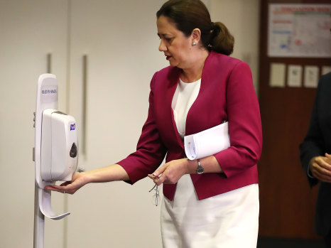 Queensland Premier Annastacia Palaszczuk sanitizes her hands at parliament house. 