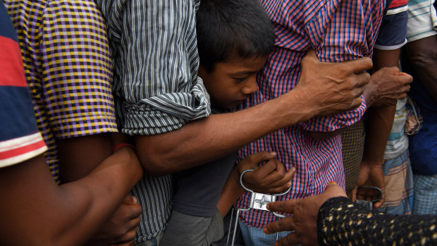 A young boy among men: refugees queuing for a meal provided by a Turkish aid agency at a food distribution site in Shofiullah Kata Camp.