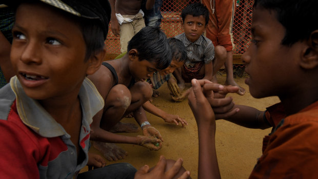 Rohingya children play in the mud with marbles in Kutupalong refugee camp after a monsoonal downpour.