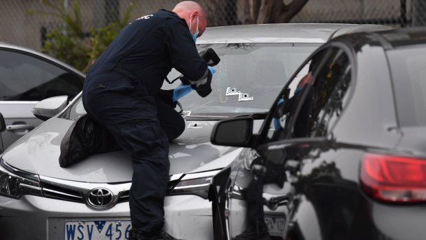 Police examine bullet holes after a junior officer fired shots into the shoulder of a man at Tullamarine early on Friday.