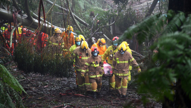 Emergency crews rescue a woman in Olinda on Thursday.
