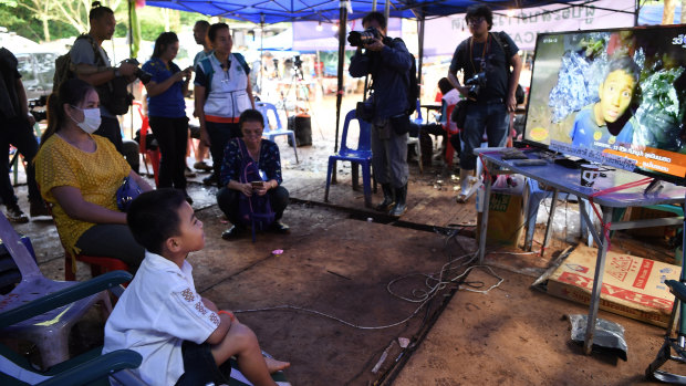 Beam Wongsookjan, 5, second from left,  watches footage of his older brother and the other boys.