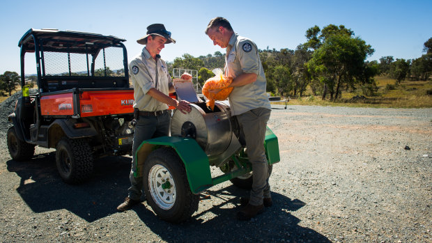 Mulligans Flat and Goorooyaroo Nature Reserve ranger in charge Simon Stratford and Mulligans Flat Sanctuary manager Will Batson prepare the bait distributor with carrots for the rabbit and hare eradication program.