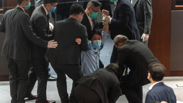 Pro-democracy member of the Hong Kong Legislative Council Ted Hui Chi-fung being removed by security during a scuffle with pro-Beijing legislators.