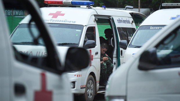 A Thai army medic sits in an ambulance on standby for the rescue operation in a restricted area near Tham Luang cave. 