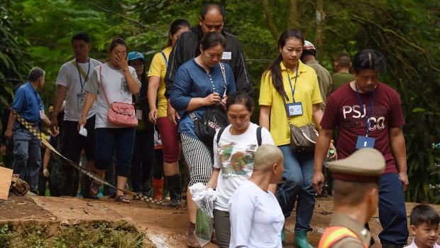 The families of the trapped boys and their coach return from praying at Tham Luang cave on Saturday.