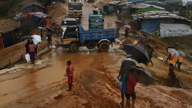 Trucks, rickshaws and people negotiate their way through the mud after a monsoon downpour in Kutupalong Camp this week.