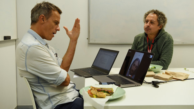 Journalist Tim Elliott and translator  Omid Tofighian talk to Behrouz Boochani over lunch.