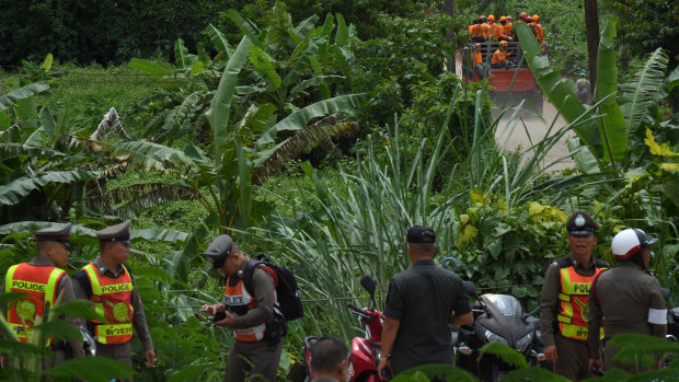 Thai rescue volunteers make their way up to the base camp near Tham Luang cave on Monday. 