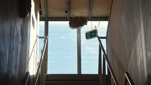 A fire exit sign was dangling from the ceiling at the site of the abandoned apartments on Tuesday. 
