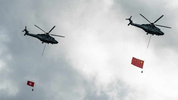 Helicopters fly the flags of China and Hong Kong over Victoria Harbour, HK, on July 1 - the first day of the new laws and the 23rd anniversary of the handover from British rule.