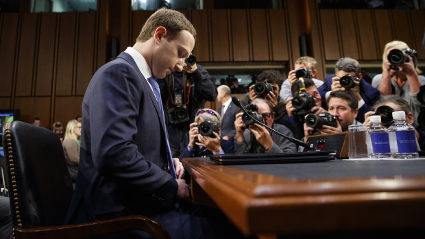 Facebook CEO Mark Zuckerberg adjusts his tie as he arrives to testify on Capitol Hill in April 2018. 