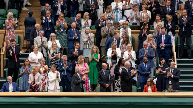 Royals and spectators stand for Sarah Gilbert, seated at bottom right, at Wimbledon’s Centre Court. 