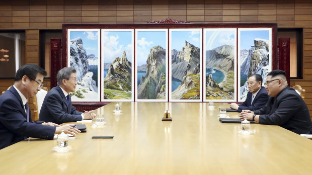 Moon Jae-in, second from left, and Kim Jong Un, right, talk during their meeting on May 26.
