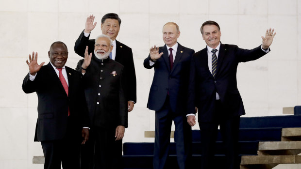 From left to right, South Africa's President Cyril Ramaphosa, India's Prime Minister Narendra Modi, China's President Xi Jinping, Russia's President Vladimir Putin and Brazil's President Jair Bolsonaro wave to photographers during the BRICS Summit in Brasilia.