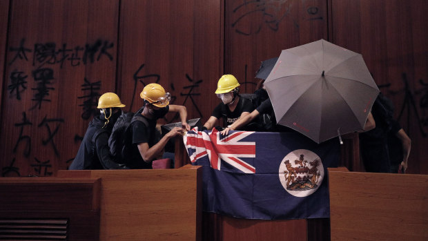 Protesters with a colonial-era flag storm Hong Kong's Legislative Council on July 1.