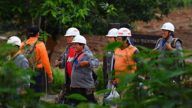 All smiles: Rescue workers cannot contain their happiness at the success of the operation. 