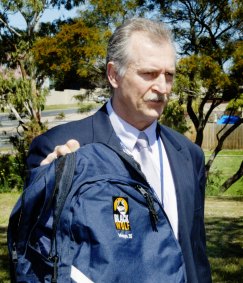 Detective Senior Sergeant Lucio Rovis holds a backpack found at a murder scene.