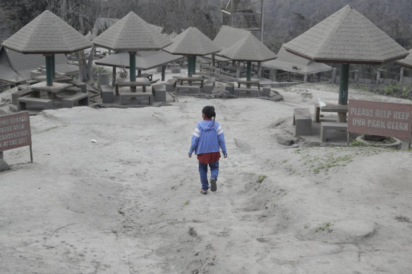 A woman walks through a park blanketed in ash in the town of Tagaytay, near the Taal volcano.