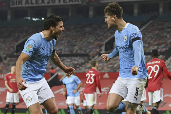 John Stones, right, celebrates scoring the opener for City at Old Trafford.