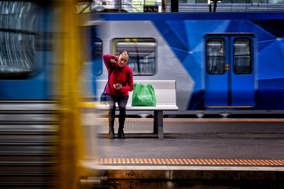 A woman waits at an almost-empty Southern Cross station.