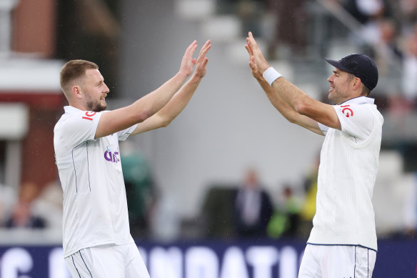 Newcomer Gus Atkinson (left) takes a West Indian wicket and the congratulations of his outgoing teammate James Anderson (right).