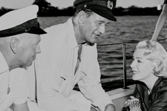 Director John Farrow (left) with John Wayne and Lana Turner on the set of The Sea Chase. 