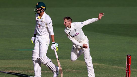 England’s Joe Root, right, bowls past Australia’s Mitchell Starc during the fourth day of their Ashes cricket test match in Adelaide, Australia, Sunday, Dec. 19, 2021. (AP Photo/James Elsby)